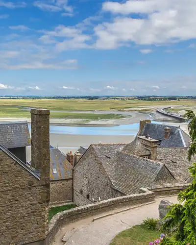 Mont-St-Michel, France. The buildings of the abbey and the mouth of the river in the background